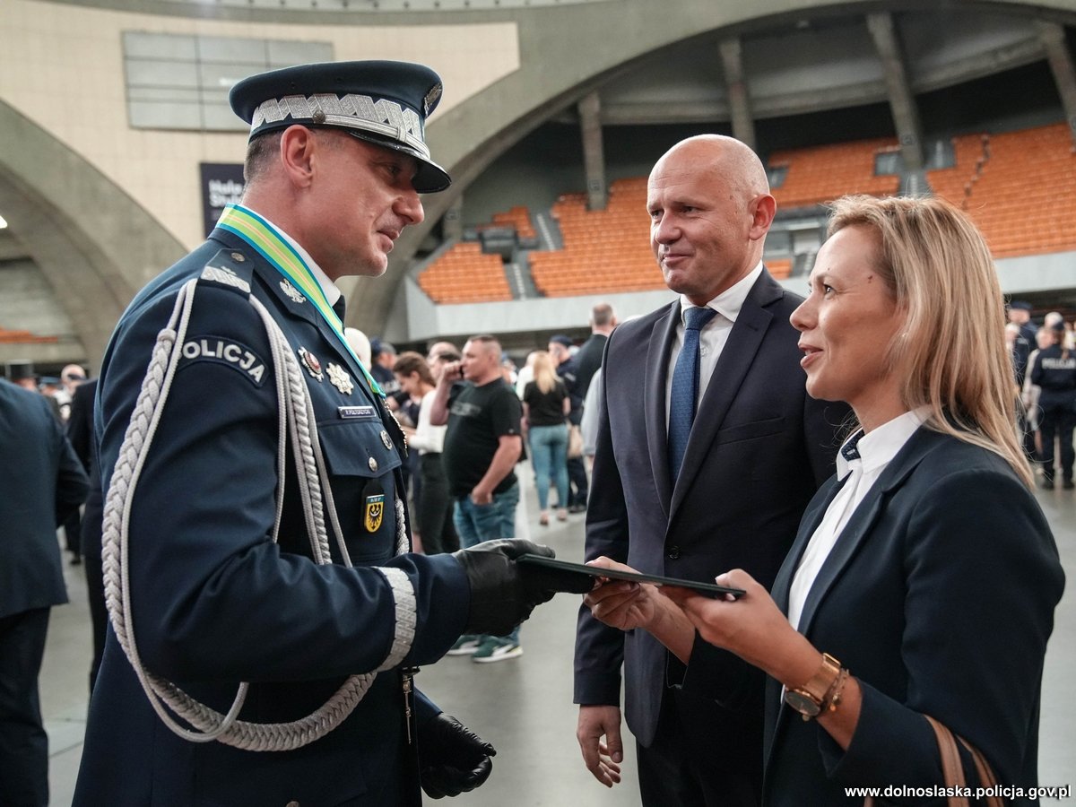 Dolnośląski Wojewódzki Inspektor Ochrony Środowiska wręcza podziękowania na ręce Komendanta Wojewódzkiego Policji we Wrocławiu na obchodach z okazji Święta Policji. Obok Dolnośląskiego Wojewódzkiego Inspektora Ochrony Środowiska stoi zastępca.