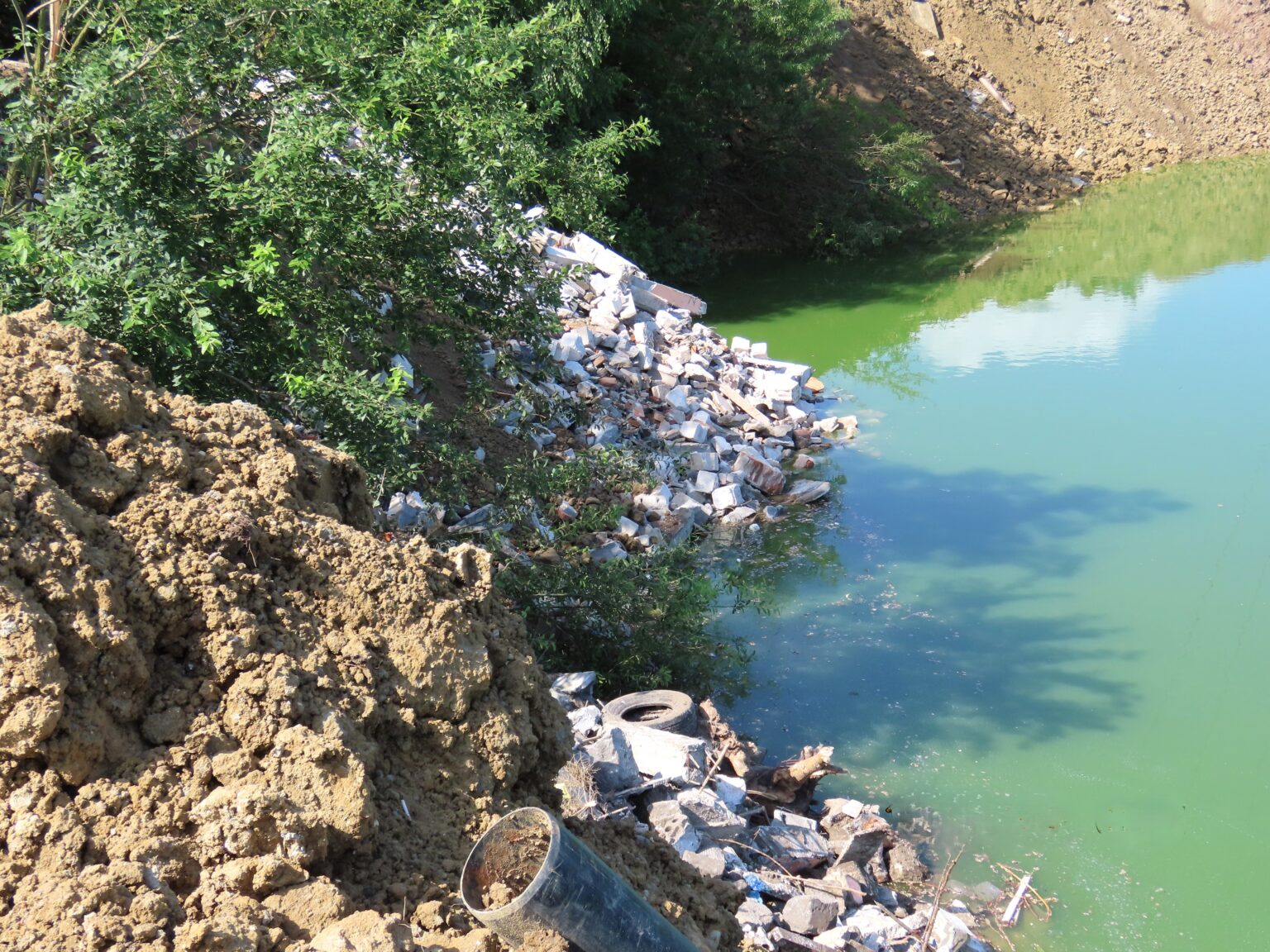 Na linii brzegowej zbiornika wodnego znajdują się zdeponowane odpady w postaci gruzu, piasku, gliny, ziemi zawierającej kamienie.